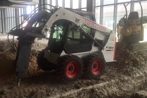 Bobcat S450 with breaker breadking concrete floor