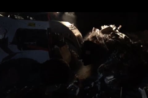 Bobcat Skid-Steer Loader cleaning up debris indoors.