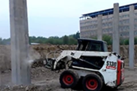 Bobcat S130 Skid-Steer Loader crushing a concrete pile