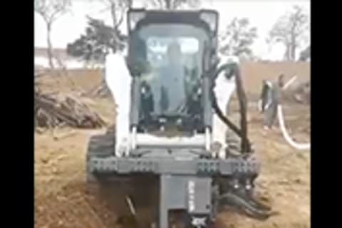 Bobcat S770 Skid-Steer with trencher application digging a trench