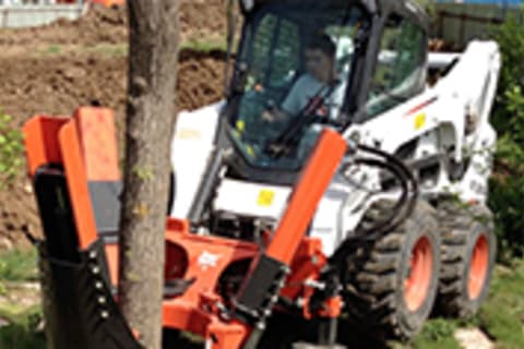 Bobcat Steer-Loader with tree spade attachment digging up a tree