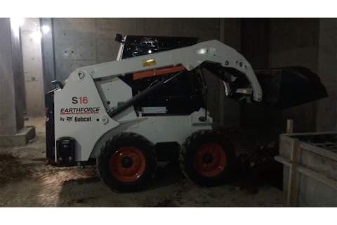 Bobcat Skid-Steer Loader backfilling dirt in a basement.