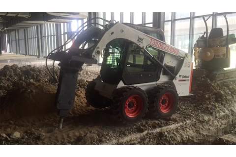 Bobcat S450 with breaker breadking concrete floor