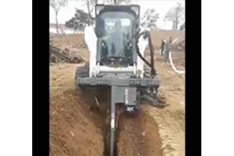 Bobcat S770 Skid-Steer with trencher application digging a trench
